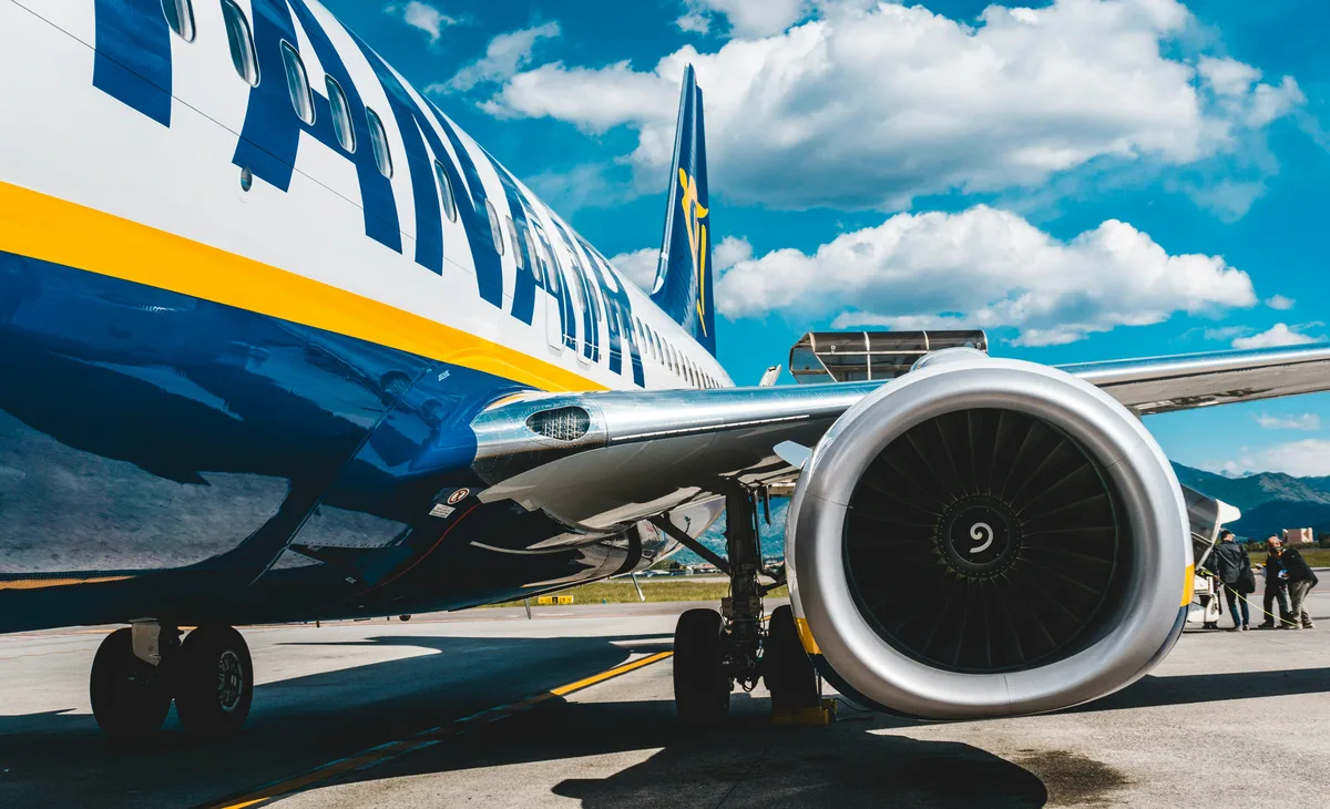 A Ryanair Boeing 737 on an airport apron, seen from beside the engine and forward fuselage.